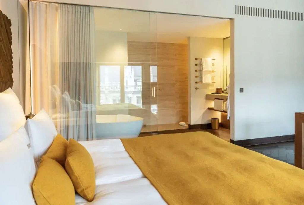 Moderner Schlafbereich mit Bad und Glaswand in der Junior-Suite