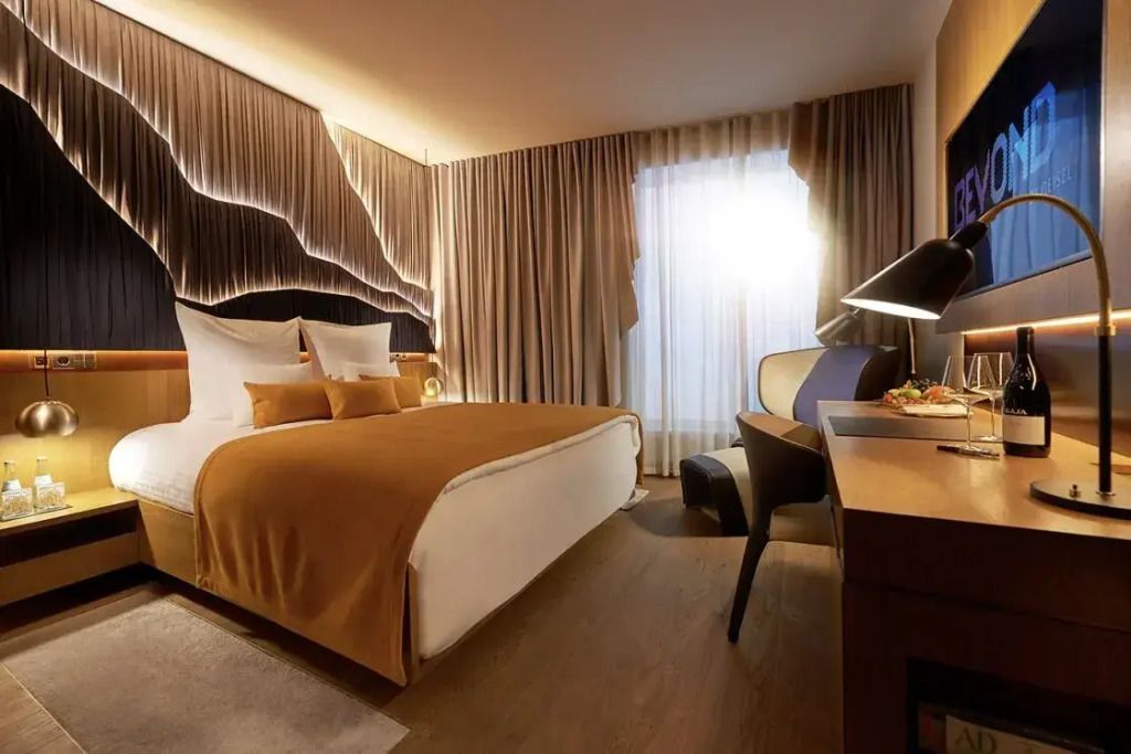 Geräumiges Doppelzimmer mit elegantem Doppelbett und modernem Schreibtischbereich.