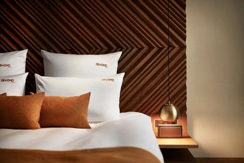 Stilvolles Doppelbett mit Holzpaneel und goldener Lampe auf Nachttisch