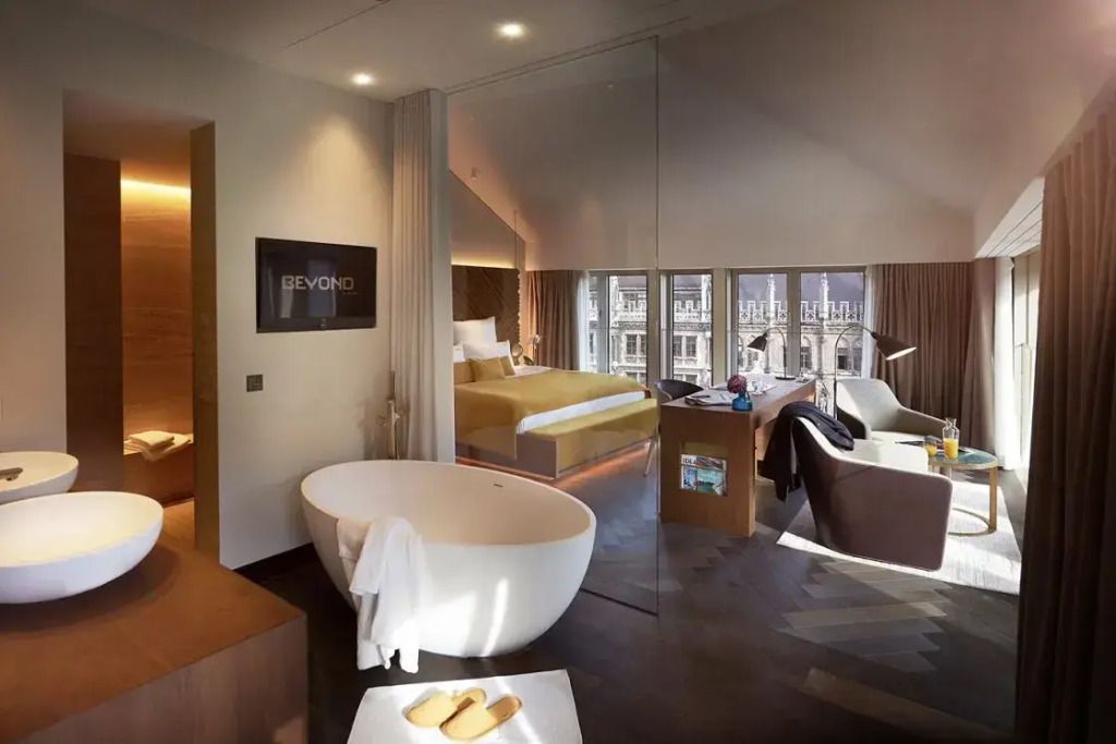 Moderne Suite mit freistehender Badewanne und Blick auf die Doppelbettausstattung
