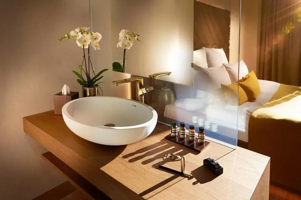 Luxuriöses Badezimmer mit Designer-Waschbecken und goldenen Armaturen