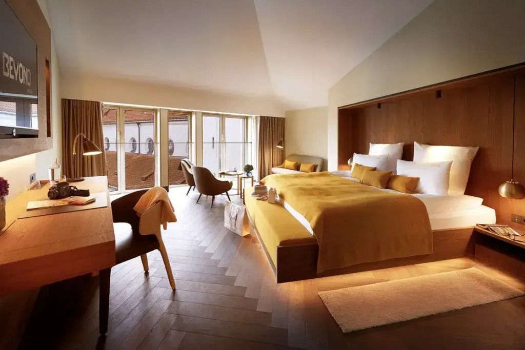 Großzügige Junior Suite mit Doppelbett und Sitzbereich in warmen Tönen