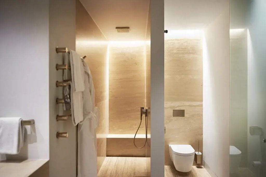 Modernes Badezimmer mit beiger Beleuchtung, Regendusche und Handtuchhalter
