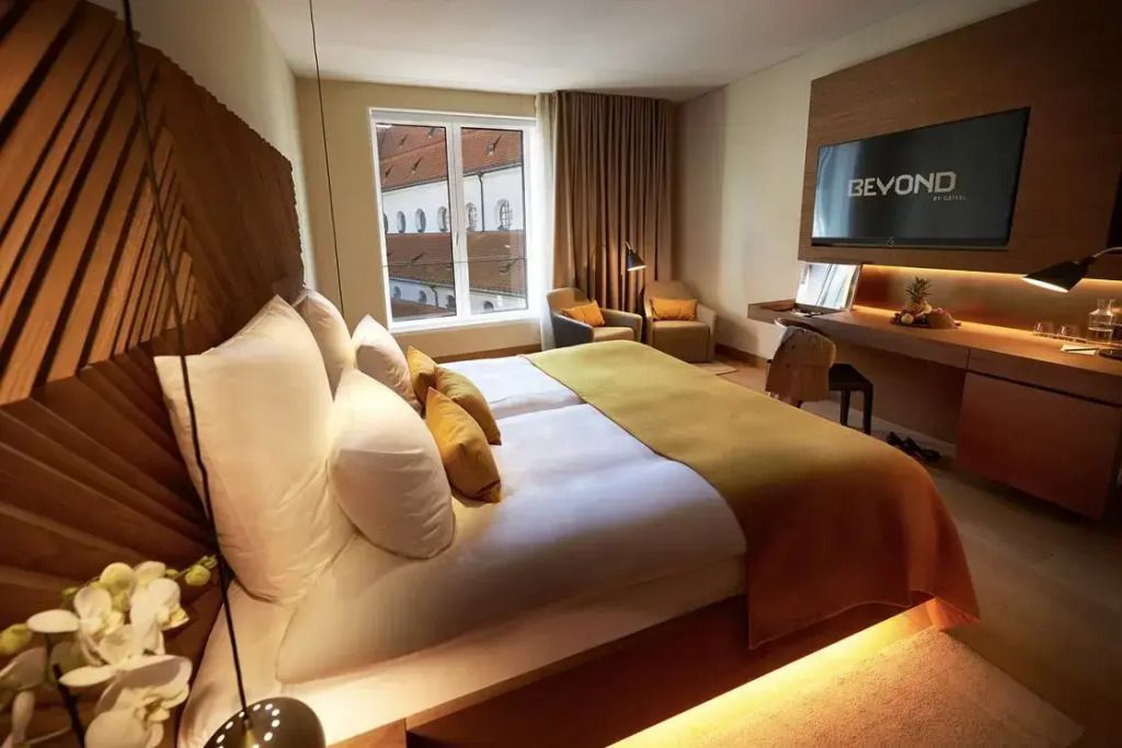 Helles Doppelzimmer mit großem Fenster und Fernseher mit Beyond-Logo