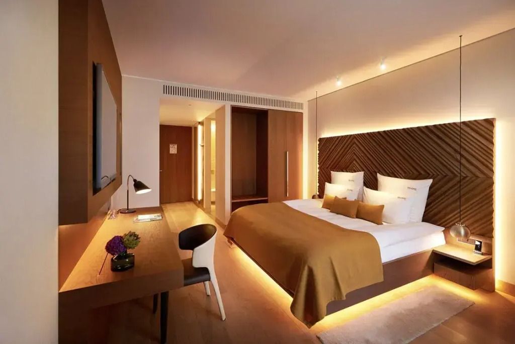 Geräumiges Zimmer mit Doppelbett Schreibtisch und moderner Beleuchtung