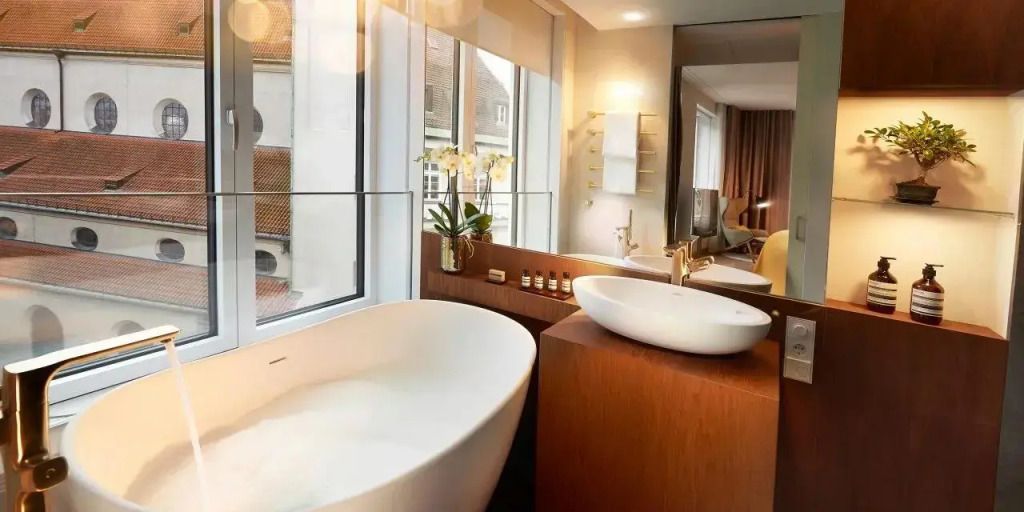 Elegantes Badezimmer mit freistehender Badewanne und Fensterblick auf historische Gebäude