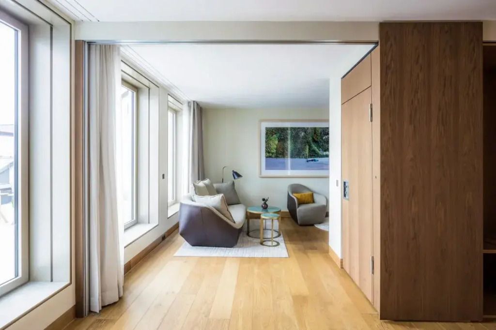 Helles Wohnzimmer mit großen Fenstern und modernen Möbeln