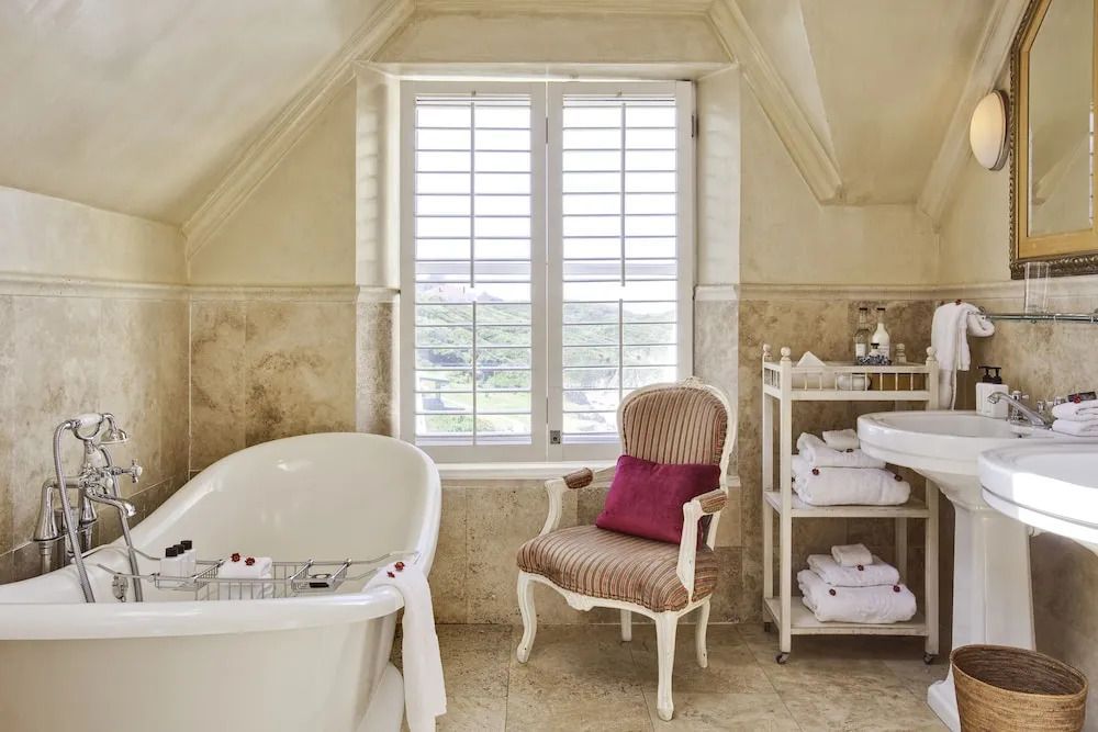 Helles Badezimmer mit freistehender Badewanne und Sitzgelegenheit