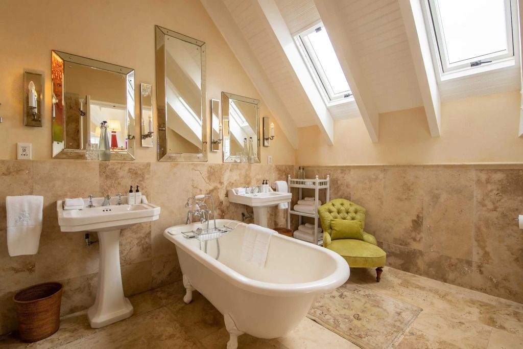 Helles Badezimmer mit freistehender Badewanne unter Dachfenstern.