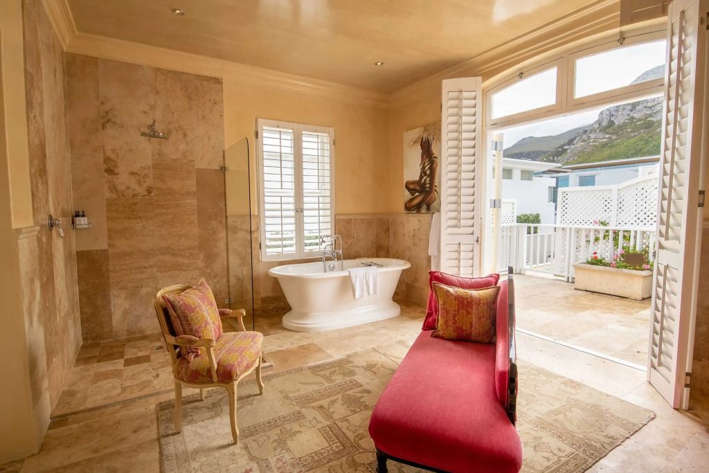Badezimmer mit freistehender Badewanne und eleganten Möbeln mit Zugang zur Terrasse.
