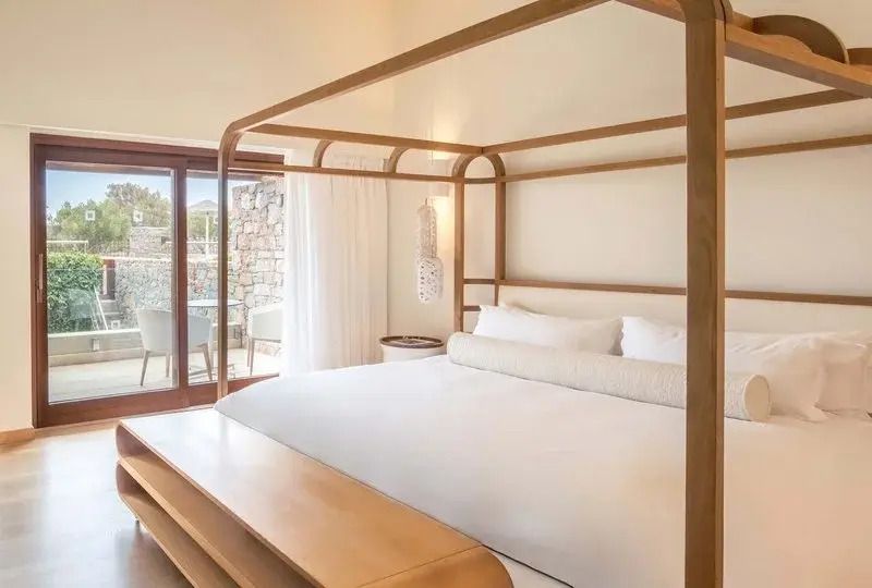 Geräumiges Schlafzimmer mit Himmelbett und Zugang zur Terrasse in der Blue Maisonette Suite