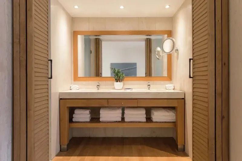 Modernes Badezimmer mit Doppelwaschbecken und großem beleuchtetem Spiegel
