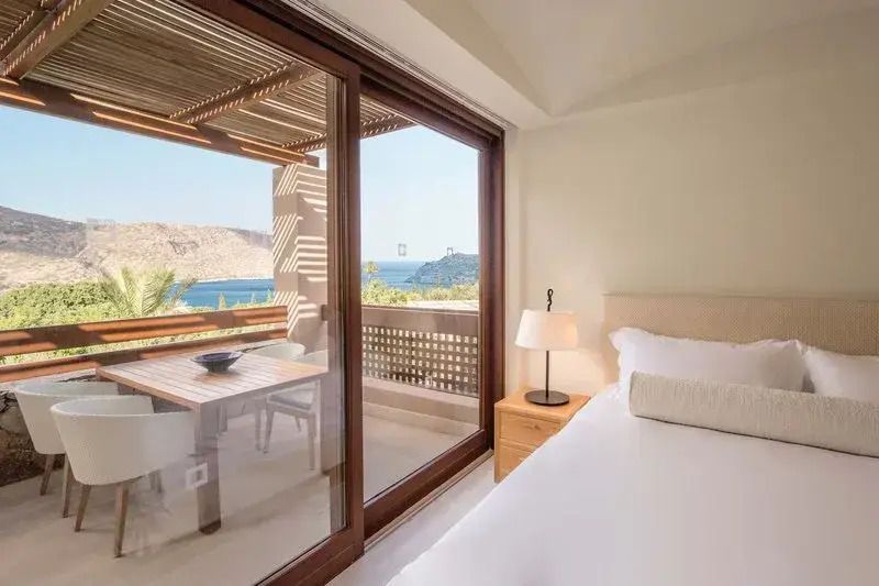 Schlafzimmer mit Meerblick und Balkon im Deluxe Bungalow