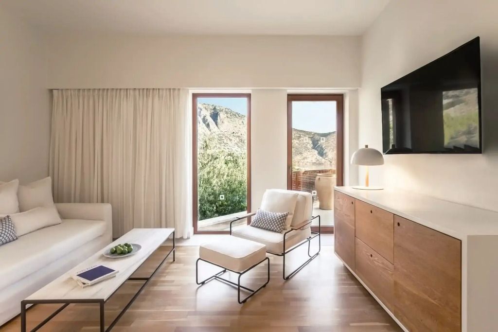 Wohnbereich einer Suite mit modernen Möbeln und Zugang zur Terrasse