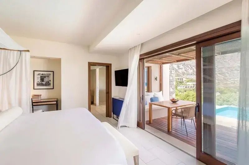 Heller Wohnbereich in Suite mit Zugang zu privatem Balkon und Blick aufs Meer