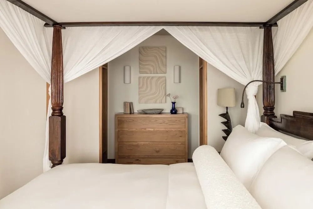 Elegantes Schlafzimmer mit Himmelbett und feinen Holzdetails