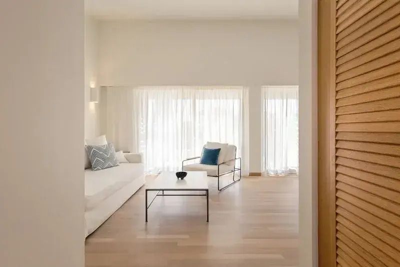 Helles Wohnzimmer mit Sofa und Sesseln in moderner Suite