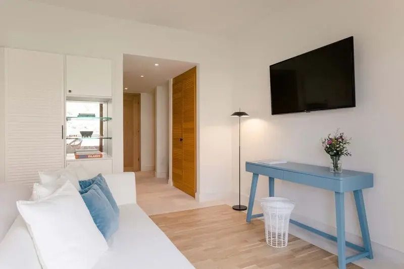 Sitzbereich mit blauen Akzenten und Wand-TV im Zimmer
