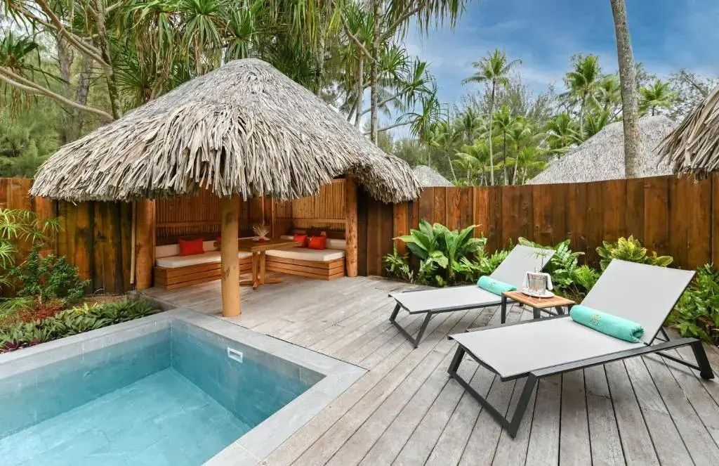 Privater Außenbereich mit Pool Loungemöbeln und tropischen Pflanzen