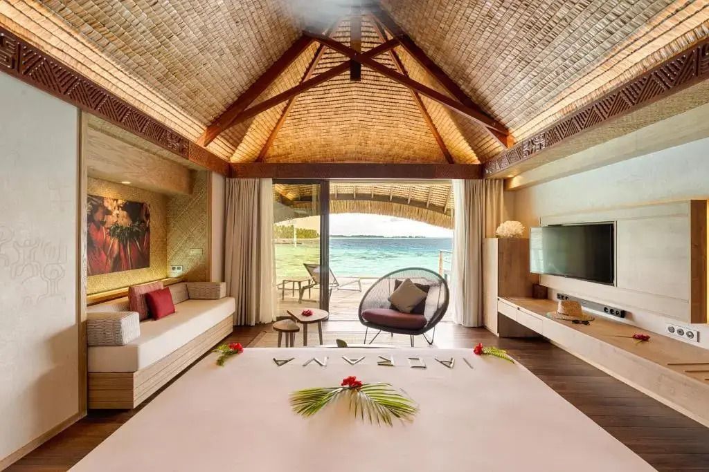 Großzügiger Wohnbereich mit Panoramablick auf das Meer im Lagoon Overwater Bungalow.