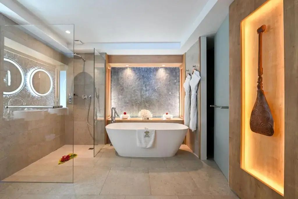 Badezimmer im Otemanu Bungalow mit freistehender Badewanne und Glasdusche.