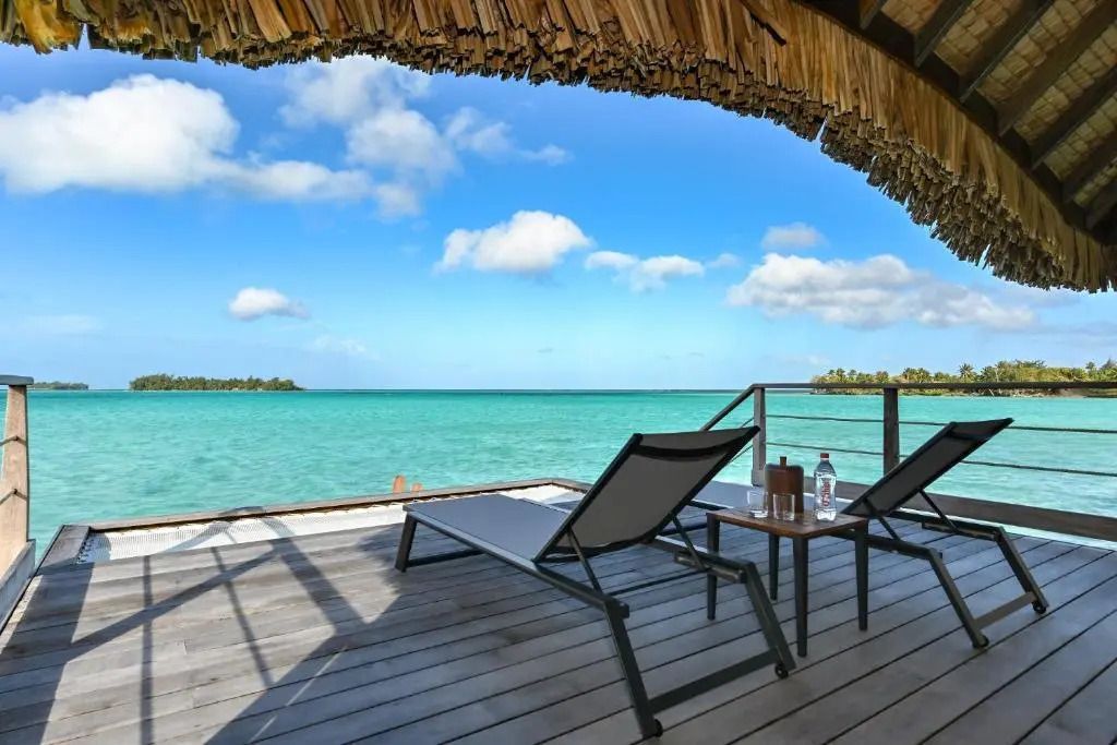 Terrasse mit Liegestühlen und Blick auf das blaue Meer und den Himmel