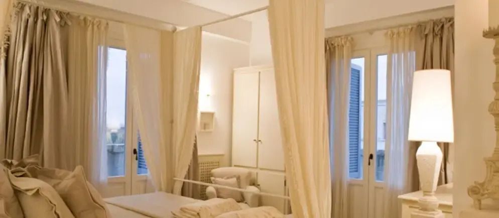 Elegantes Schlafzimmer mit Baldachinbett und sanfter Beleuchtung