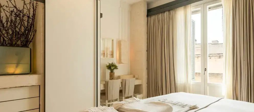 Elegantes Schlafzimmer mit stilvollen Vorhängen und Blumenarrangement.