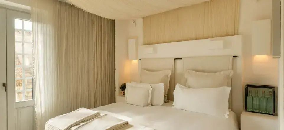 Gemütliches Schlafzimmer mit geschmackvoller Beleuchtung und stilvollen Vorhängen