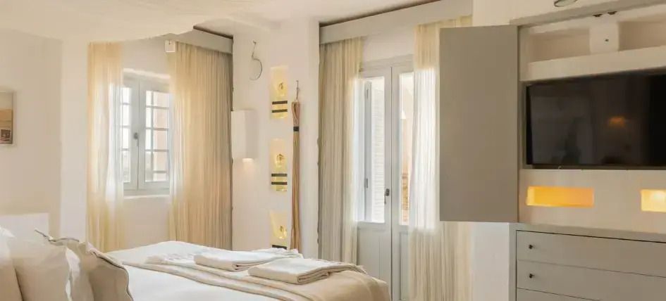 Helles Doppelzimmer mit großen Fenstern und eleganter Einrichtung im Borgo Egnazia
