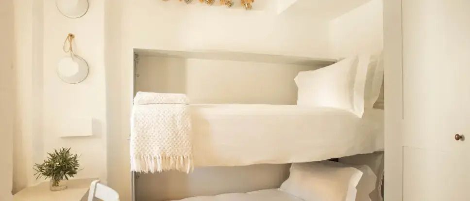 Gemütliches Zimmer mit Etagenbett und weichen Kissen im Hotel Borgo Egnazia
