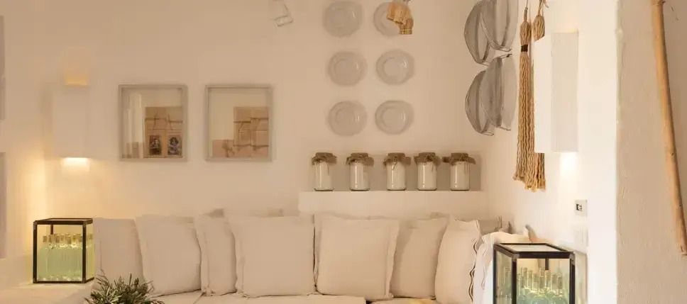 Eleganter Wohnbereich mit dekorativen Elementen und gemütlichen Sitzkissen im Borgo Egnazia