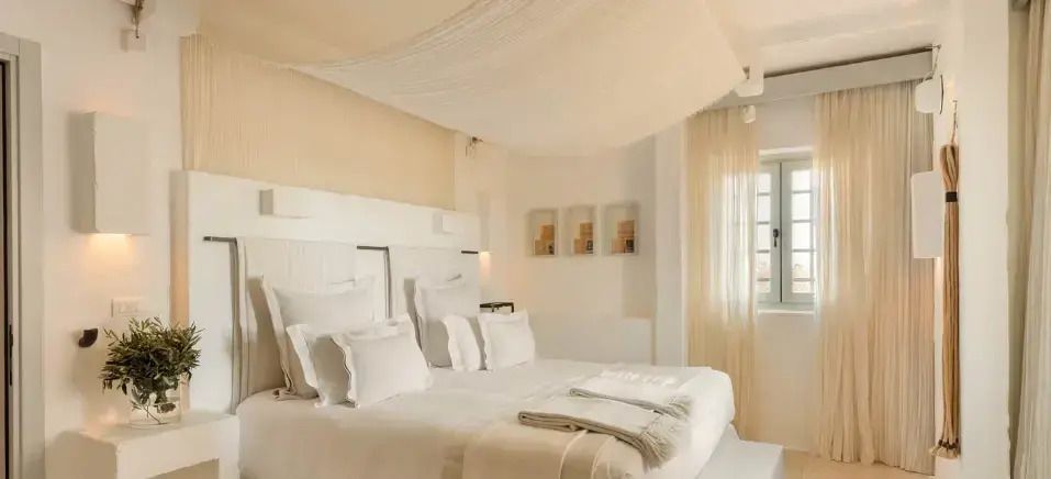 Luxuriöses Schlafzimmer mit großem Doppelbett und lichtdurchfluteten Fenstern im Borgo Egnazia
