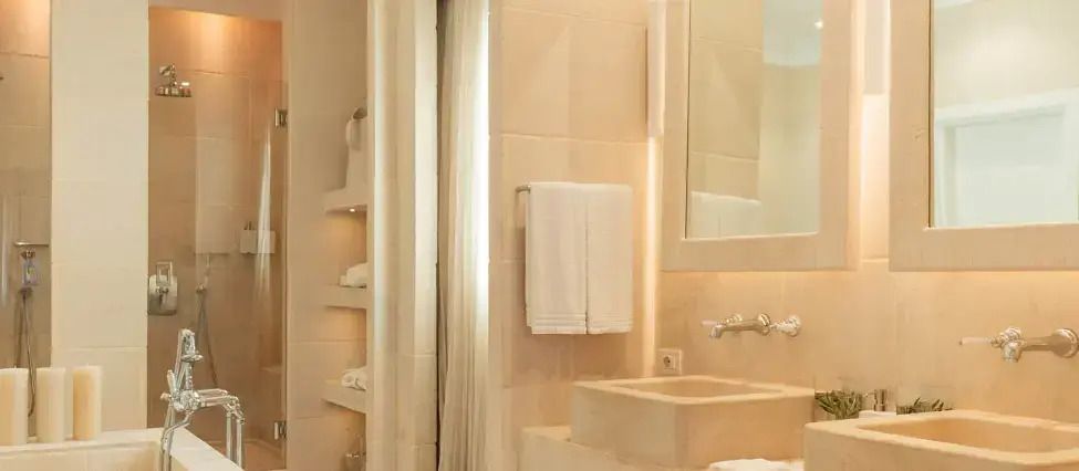 Elegantes Badezimmer mit hellem Design und Handtüchern auf einem modernen Waschbecken.