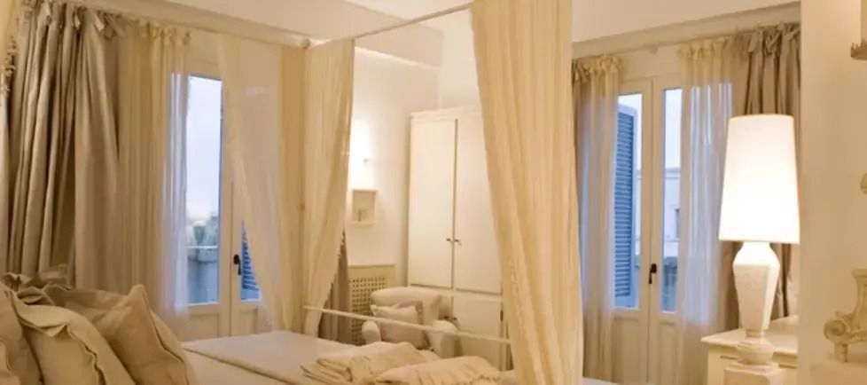 Luxuriöses Schlafzimmer im Magnifica Casa mit Himmelbett und eleganten Vorhängen