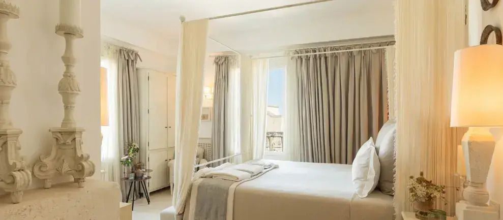 Helles Schlafzimmer mit Himmelbett und weichen Vorhängen