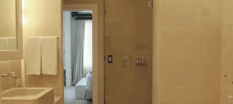 Badezimmer mit Einblick in das Schlafzimmer eines Hotels