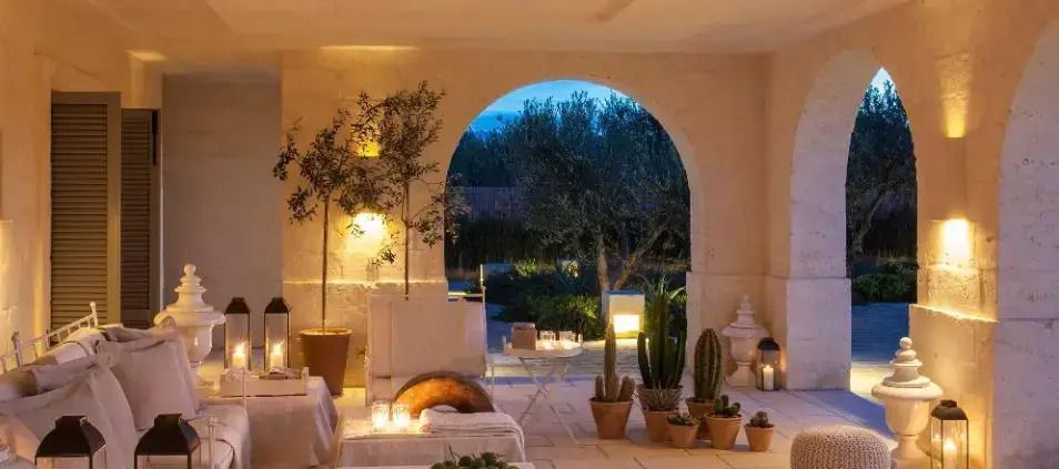 Terrasse mit Bögen, Pflanzen und stimmungsvollem Abendlicht.