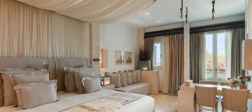 Geschmackvoll eingerichtetes Doppelzimmer mit elegantem Baldachin und Fenster mit Meerblick