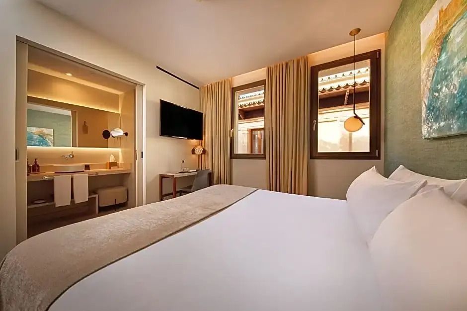 Modernes Doppelzimmer mit großem Fenster und stilvoller Einrichtung.