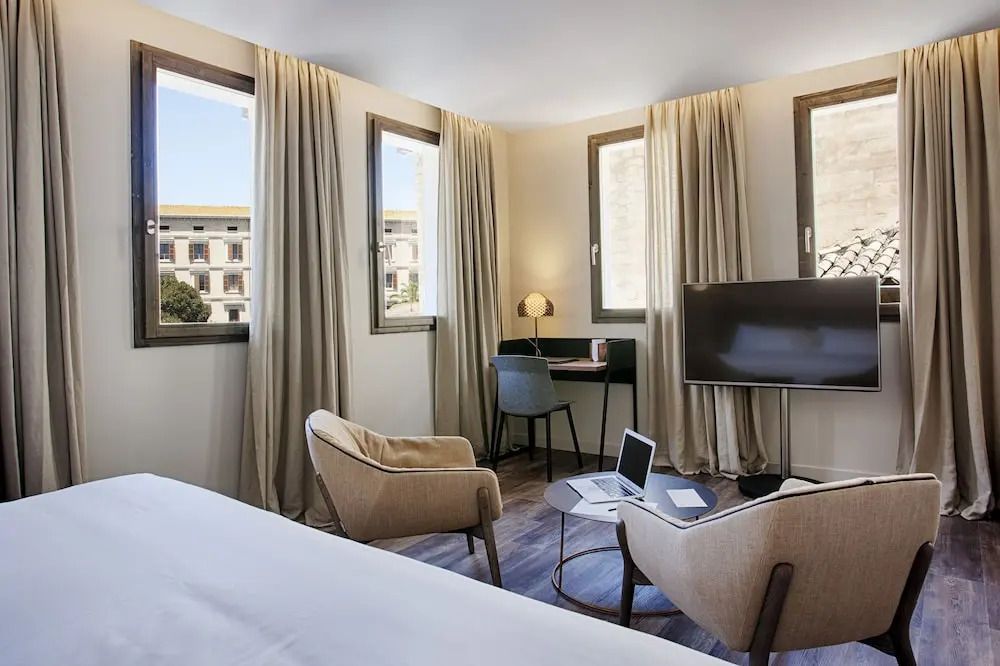 Helles Zimmer mit Schreibtisch, Fernseher und Sessel in der Junior-Suite