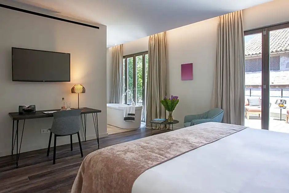 Geräumiges Zimmer mit Doppelbett, Schreibtisch, TV und Blick auf die Terrasse