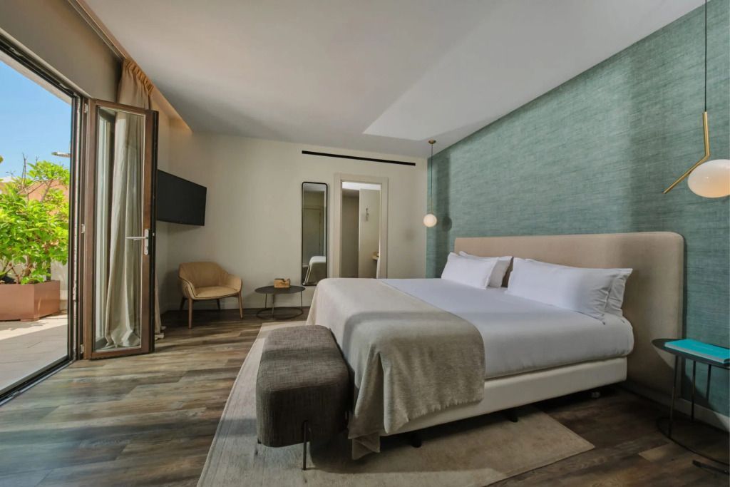 Geräumiges Zimmer mit einem großen Doppelbett und modernen Möbeln.