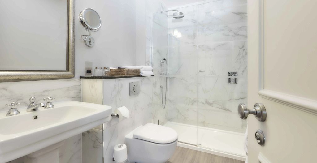Modernes Badezimmer mit Marmordekor und geräumiger Dusche im klassischen Zimmer