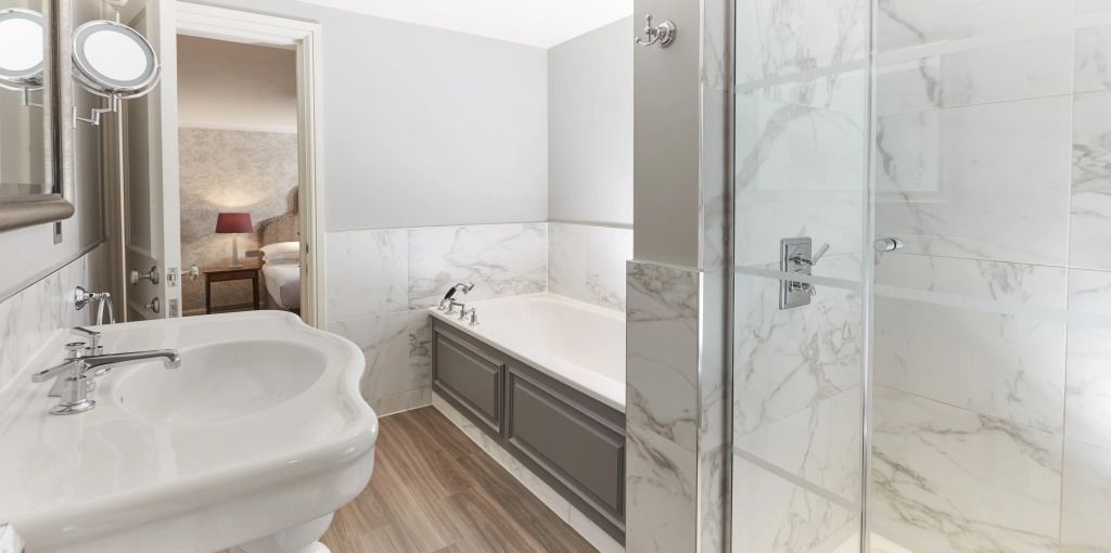 Elegantes Badezimmer mit Marmorakzenten und moderner Badewanne im Bovey Castle.