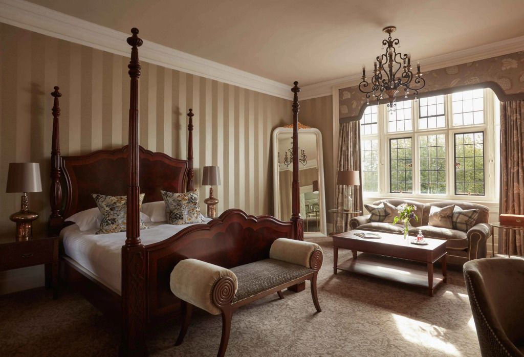 Schlafzimmer mit Himmelbett und schönem Spiegel im Bovey Castle.
