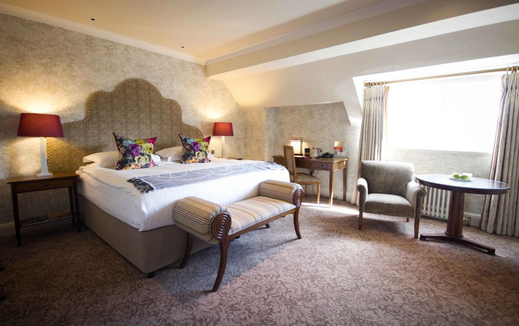 Gemütliches Schlafzimmer mit Schreibtisch und bequemen Sitzgelegenheiten im Bovey Castle.