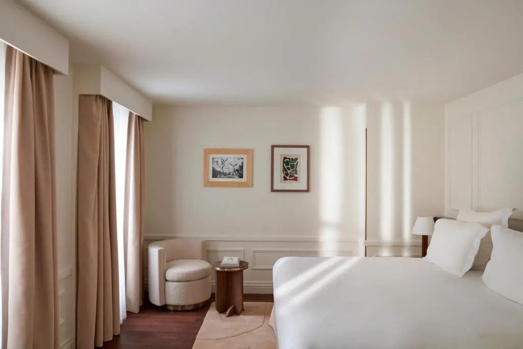 Elegantes Zimmer mit Doppelbett und weichen Vorhängen in hellen Tönen