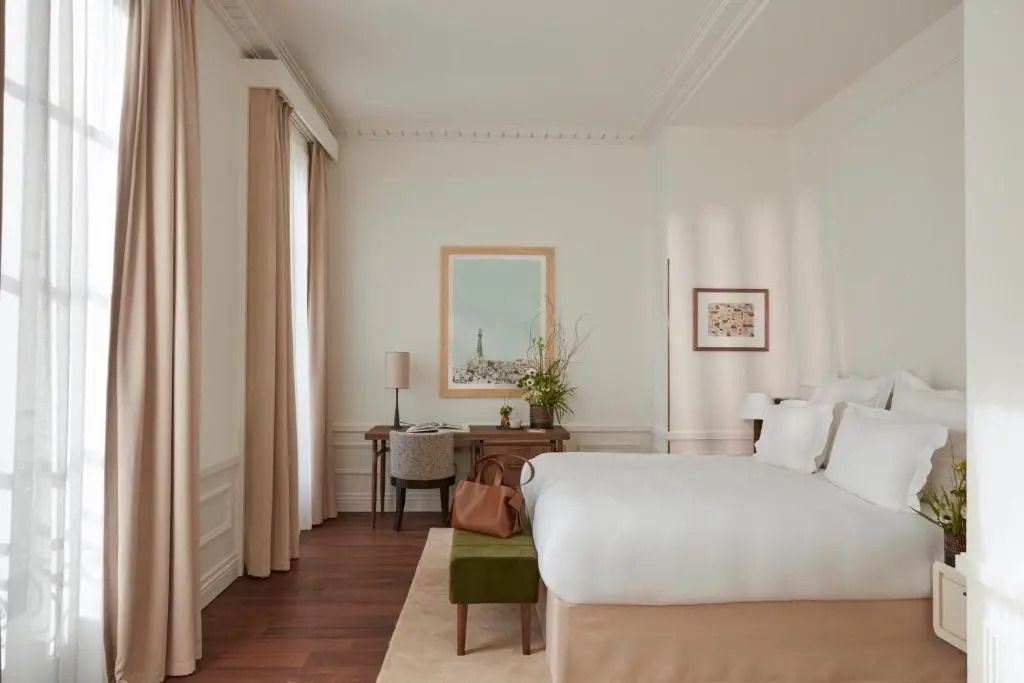Junior-Suite mit Schreibtisch, Doppelbett und Wanddekor in neutralen Tönen