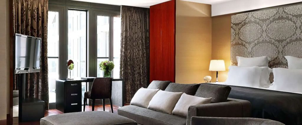 Geräumiges Wohnzimmer mit eleganter grauer Couch und großen Fenstern